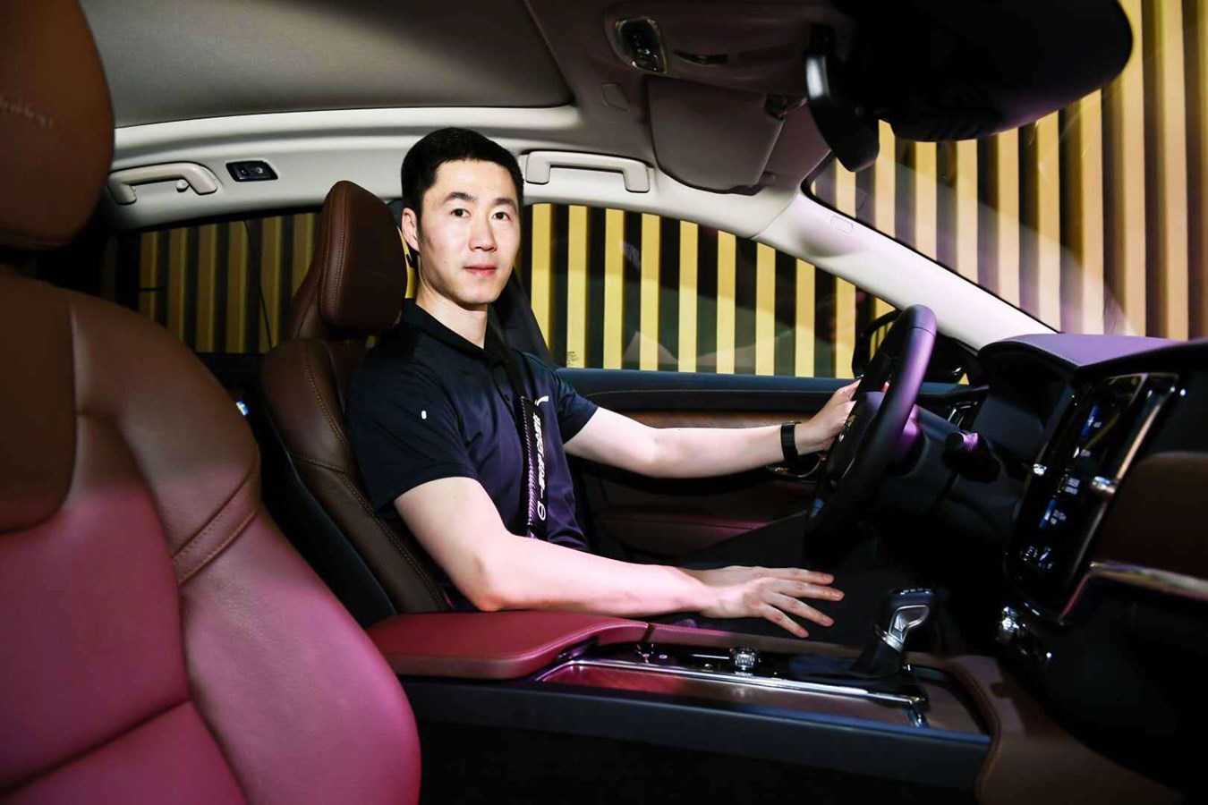 中国乒协副主席王励勤在活动现场沃尔沃S90展车上展示安全带使用方法